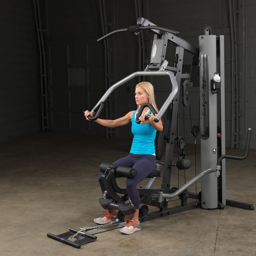 Female athlete midway through chest press on Body-Solid G5S Home Gym, arms bent at 90 degrees.