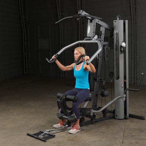 Female athlete starting chest press on Body-Solid G5S Home Gym, arms extended back.