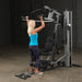 Female athlete executing a standing shoulder press on Body-Solid G5S Home Gym