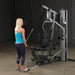 Female athlete performing tricep pushdown on Body-Solid G5S Home Gym, standing further from the machine.