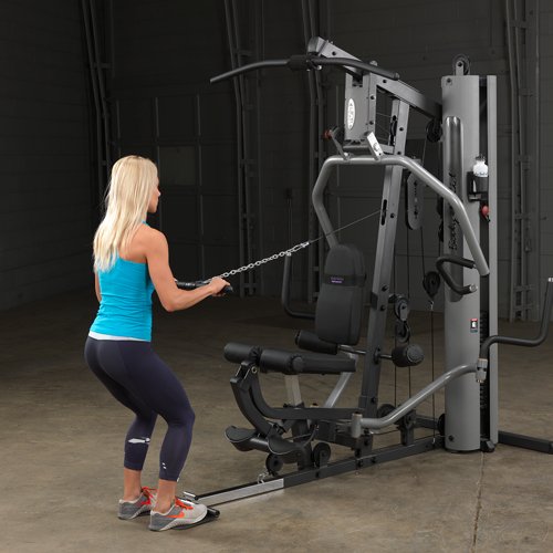 Female athlete doing mid pulley standing rows on Body-Solid G5S Home Gym, pulling handle towards her chest
