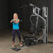 Female athlete executing lateral twist on Body-Solid G5S Home Gym using mid cable attachment.
