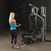 Female athlete performing standing bicep curl from low cable on Body-Solid G5S Home Gym.