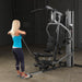 Female athlete nearly completing upright cable row on Body-Solid G5S Home Gym