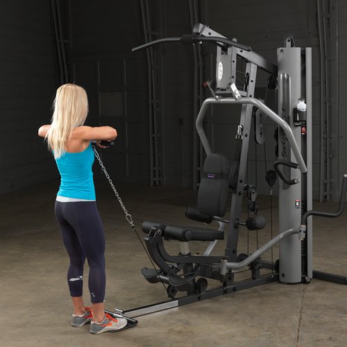 Female athlete completing upright cable row on Body-Solid G5S Home Gym with elbows fully raised.