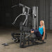 Female athlete using optional leg press attachment on Body-Solid G5S Home Gym for lower body workout.