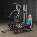 Female athlete using optional leg press attachment for calf extensions on Body-Solid G5S Home Gym.