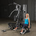 Female athlete performing hip adductor exercise with optional attachment on Body-Solid G5S Home Gym