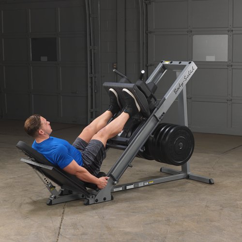 Athlete performing a fully extended leg press on the Body Solid Angled Leg Press & Hack Squat Machine, legs fully extended, demonstrating lower body strength exercise.
