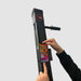 Close-up of a phone being placed into the holder on a Bluetooth-compatible VersaClimber H model, highlighting the secure fit for easy access to workout apps and fitness tracking via Bluetooth connectivity.