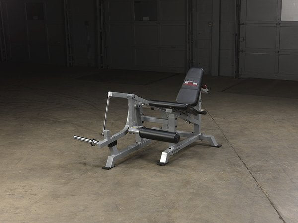 Full view of the Body-Solid Pro Clubline Leverage Leg Extension LVLE in a warehouse setting from the front right side angle, displaying its robust construction and design.