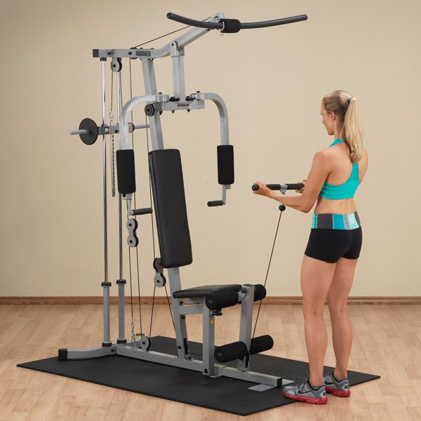 White female athlete in a teal top performing standing bicep curl from the low row cable on Powerline Home Gym PHG1000X.