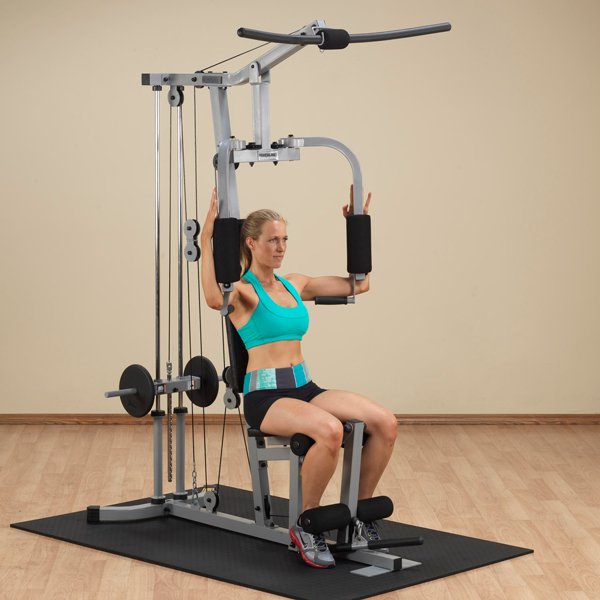 White female athlete in a teal top performing pec deck exercise on the Powerline Home Gym PHG1000X.
