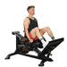 Side view of the Powertec Compact Leg Sled P-CLS23 with an athlete in the starting position, extending the leg press with weight plates loaded.