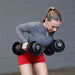 Person performing bent-over rows with Body-Solid Tools SDBX132 Adjustable Dumbbells, maintaining a flat back.