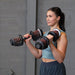 Person performing hammer curls with Body-Solid Tools SDBX132 Adjustable Dumbbells, palms facing inward.
