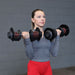 Close-up of a person performing bicep curls with a Body-Solid Tools SDBX132 Adjustable Dumbbell, focusing on the grip and weight plate alignment.