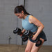 Person performing bent-over rows with Body-Solid Tools SDBX132 Adjustable Dumbbells, maintaining a flat back.