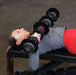 Person performing a bench press with Body-Solid Tools SDBX132 Adjustable Dumbbells on a flat weight bench.