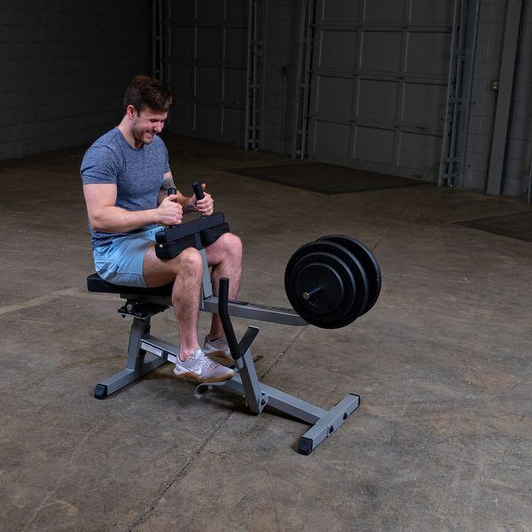 Male athlete working out on the Body-Solid GSCR349B Seated Calf Raise Machine with black weight plates, demonstrating proper use and form.