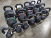 ISF kettlebells in every size, one of each, displayed on a warehouse floor.