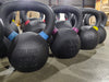 Close-up of ISF kettlebells on the warehouse floor, viewed from the left side looking right.
