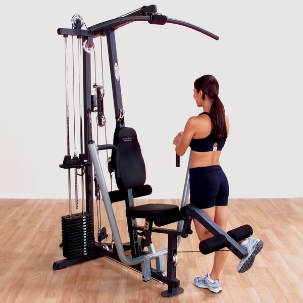 Female athlete performing a leg exercise on the leg developer of a Body-Solid G1S Multi-Station Home Gym, targeting quadriceps and hamstrings for lower body strength.