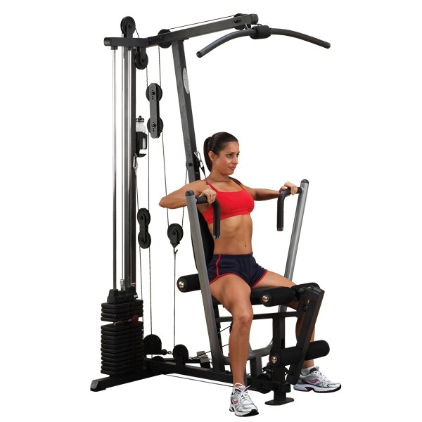Female athlete performing a chest press on the Body-Solid G1S Multi-Station Home Gym with a 160 lb weight stack, showcasing multi-grip press arms and compact full-body strength training capabilities.