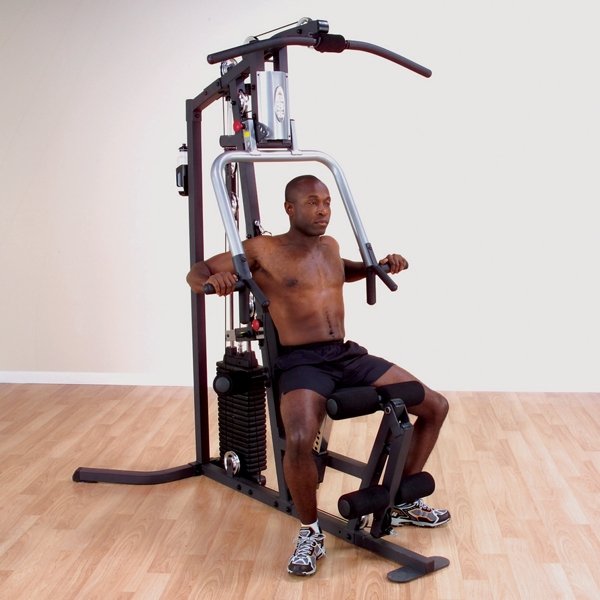 Black male athlete performing a chest press on the Body Solid Home Gym G3S using the multi-grip press arm system.