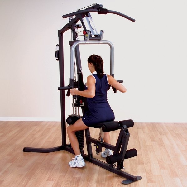 White female athlete performing rows on the Body Solid Home Gym G3S, using the mid-row handles for a back workout.