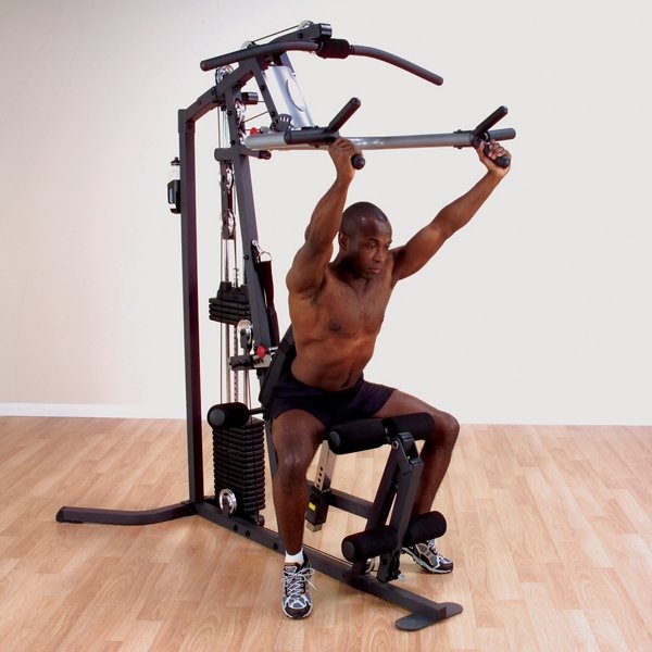 Black male athlete performing shoulder press on the Body Solid Home Gym G3S, using the multi-grip press arm system.